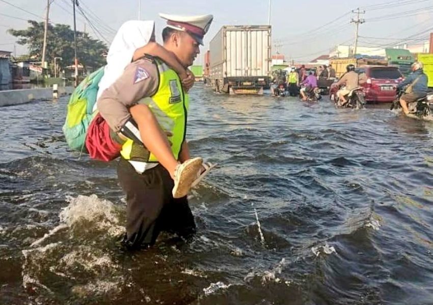 Gendong Bocah SD Sebrangi Jalan yang Terendam Banjir, Aksi Polisi ini Tuai Pujian