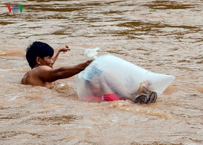 Pria di Vietnam Viral Karena Antar Anak Sekolah Menyeberang Sungai dengan Kantung Plastik